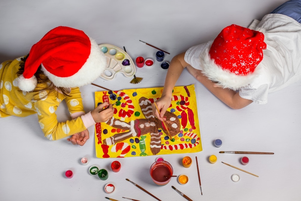 two kids painting a gingerbread man