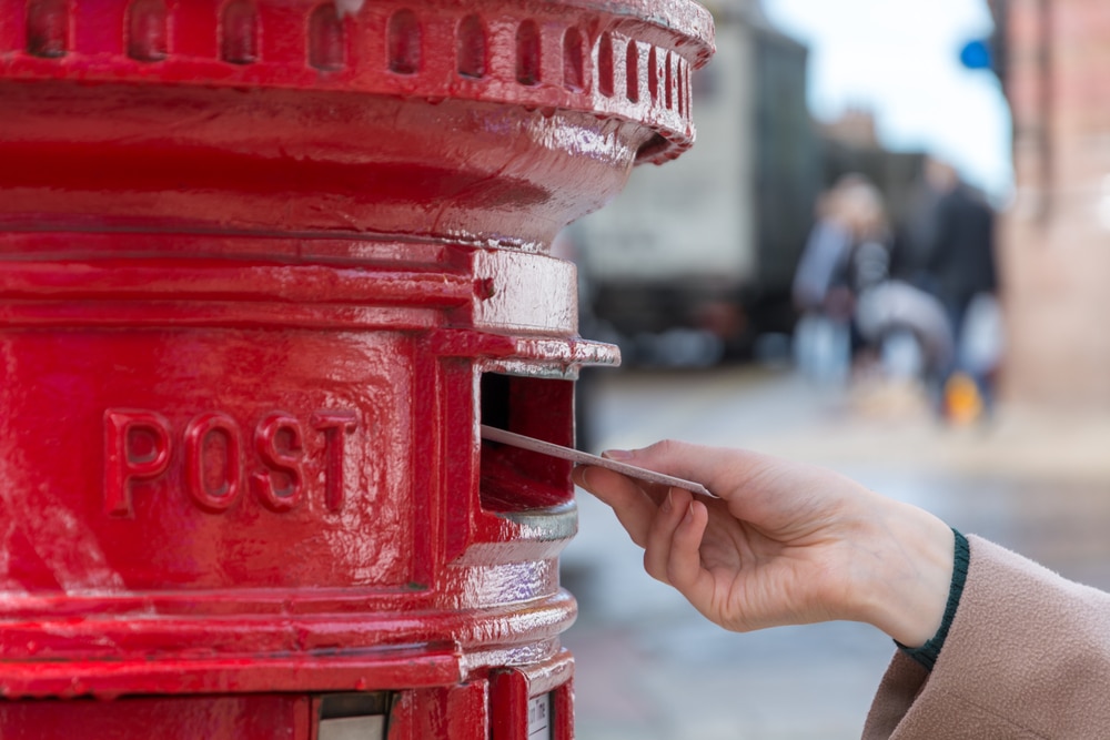 Person posting a letter in post box