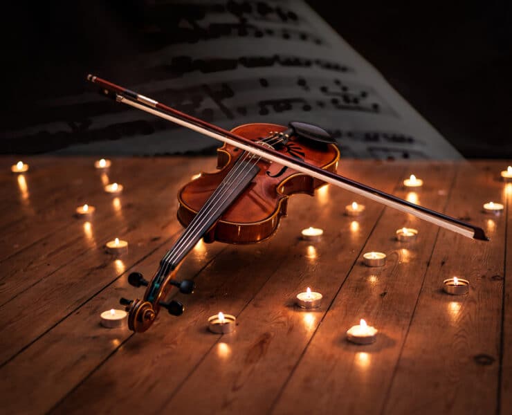 violin surrounded by candles