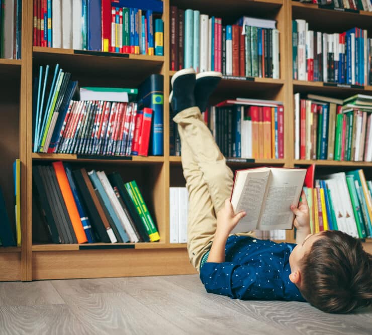 boy reading book in library