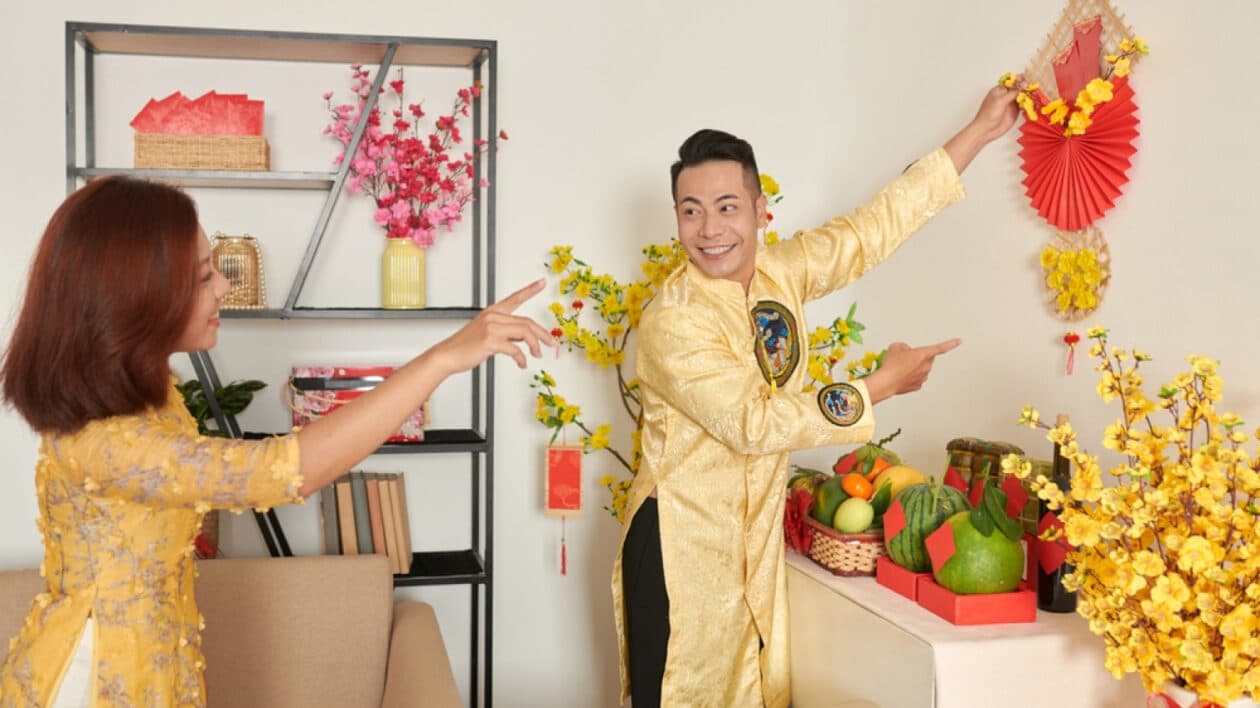 a couple decorating their house for chinese new year