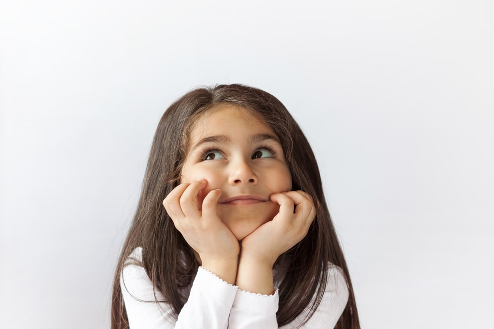Young girl thinking hard - animal riddles for kids to guess at home