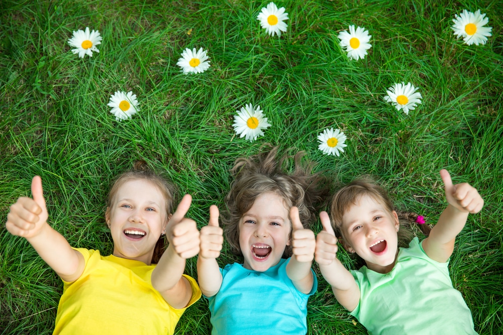 kids on the grass with their thumbs up