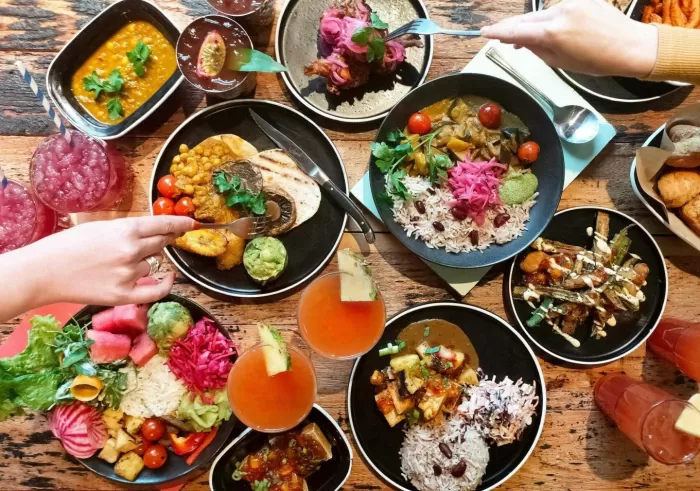 people reaching out for caribbean food at turtle bay
