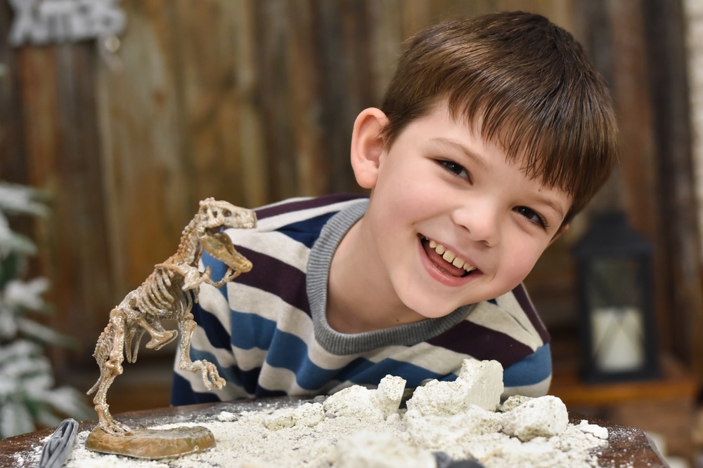 boy with tiny dinosaur skeleton