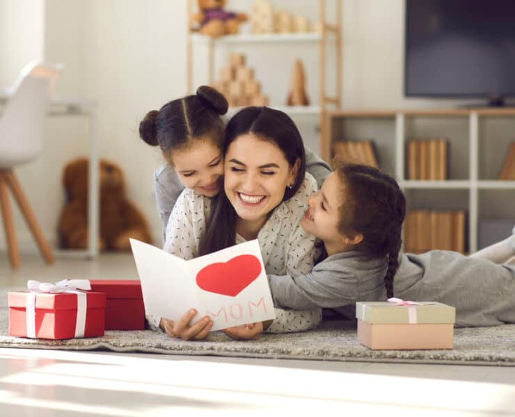 mother and daughters opening mothers day card