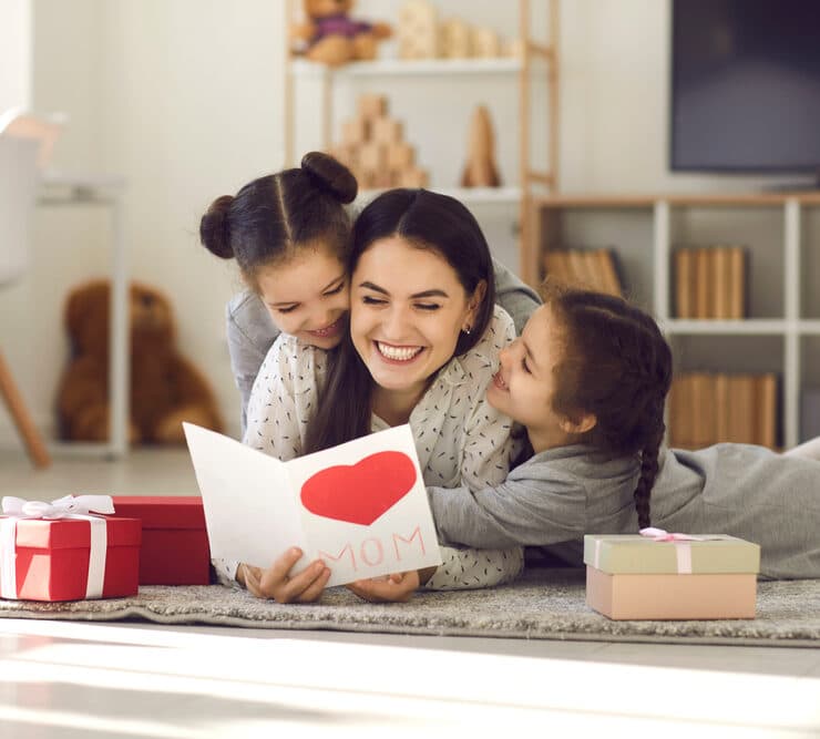 mother and daughters opening mothers day card