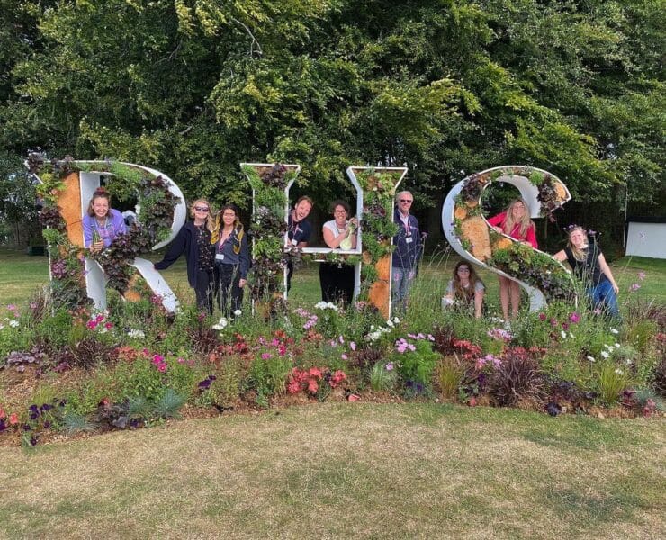 people hiding behind the RHS tatton park sign
