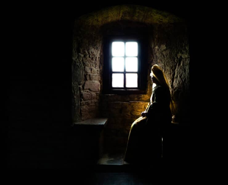 ghostly woman looking out of a castle window