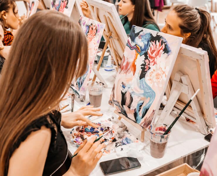 women painting on canvases