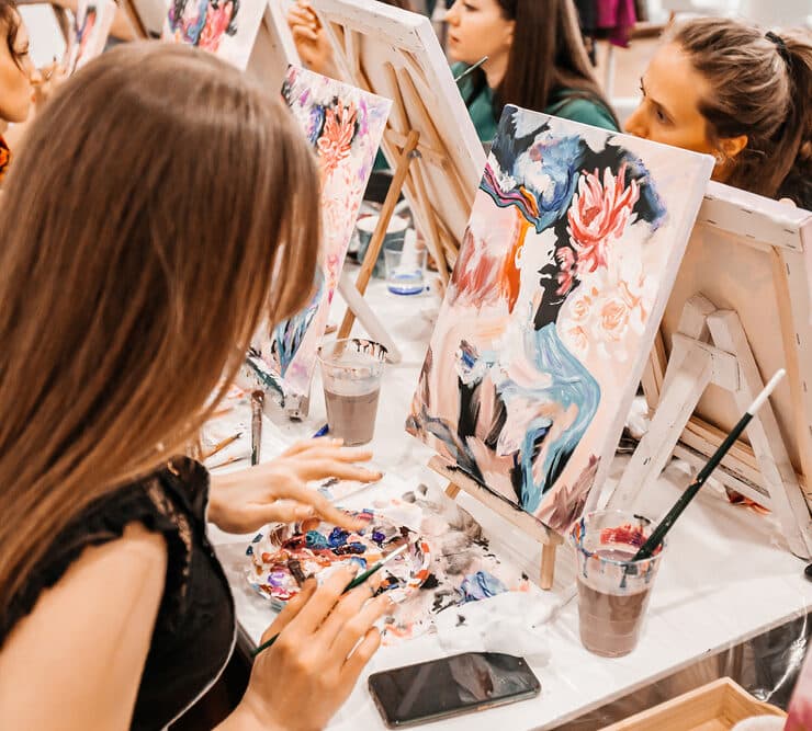 women painting on canvases