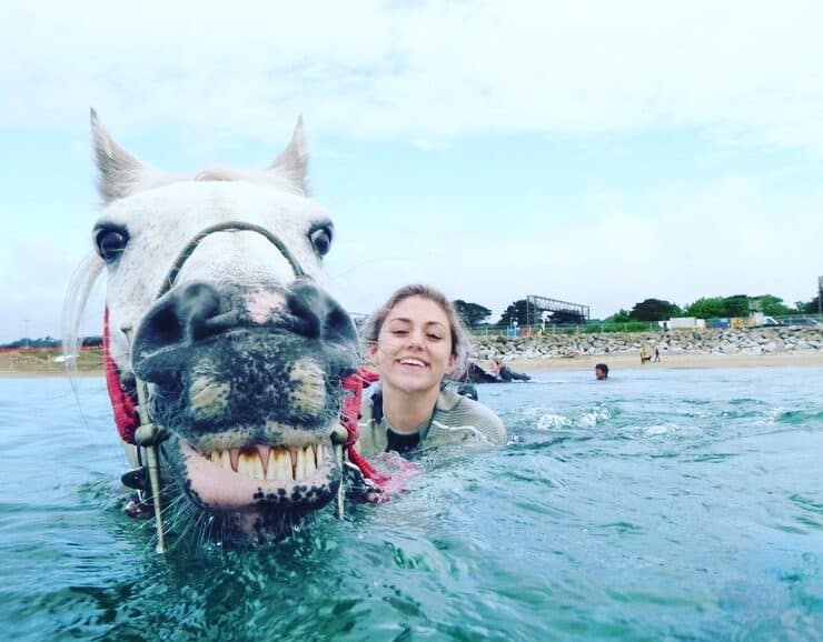 smiling girl and smiling horse in the sea