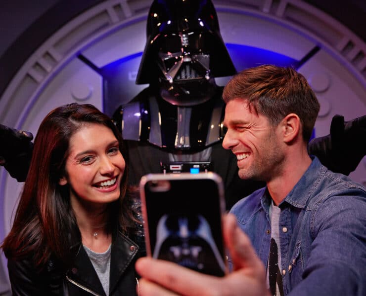 two people taking a picture with darth vader
