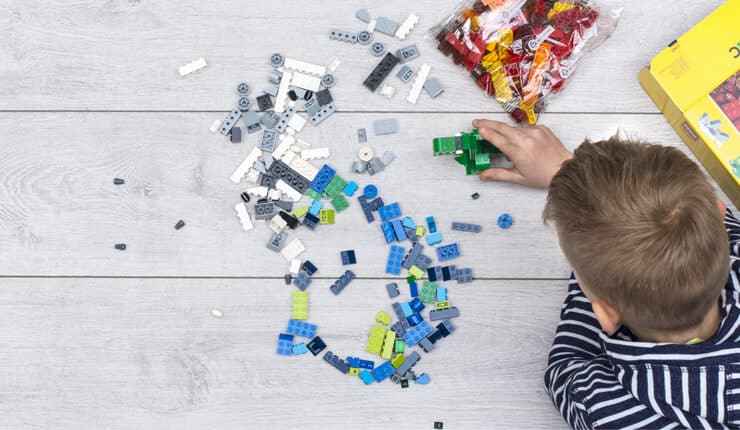 boy on the floor building lego