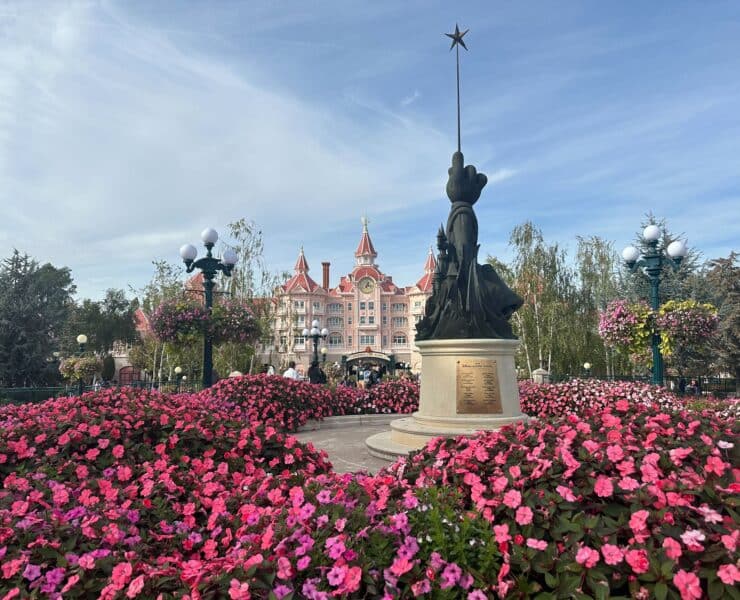 Disneyland Hotel with pink flowers in the front and a Fantasia wand statue