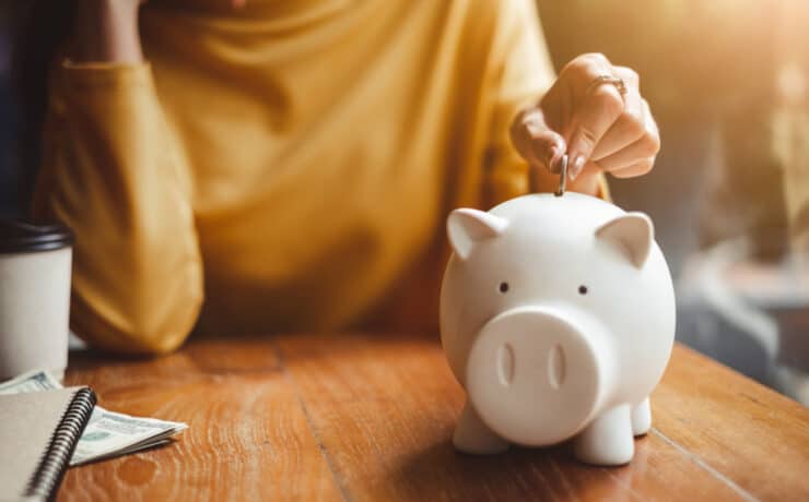 woman putting money into a piggy bank
