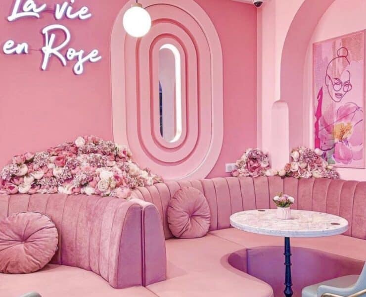 pink seating, walls and tables with a neon pink sign that says la vie en rose