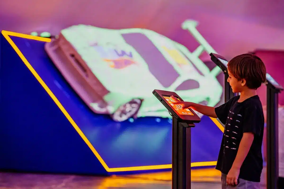 a child interacting with a hot wheels exhibit