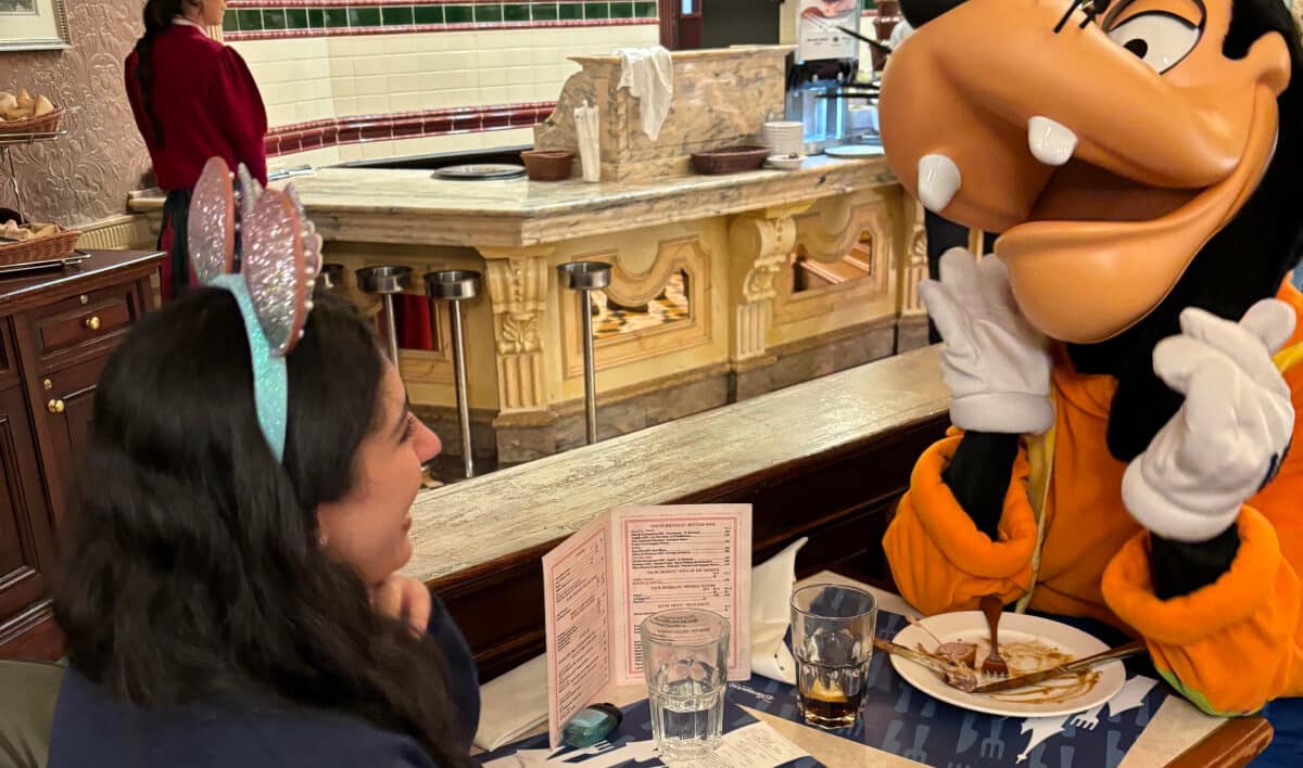goofy and woman sitting at a table
