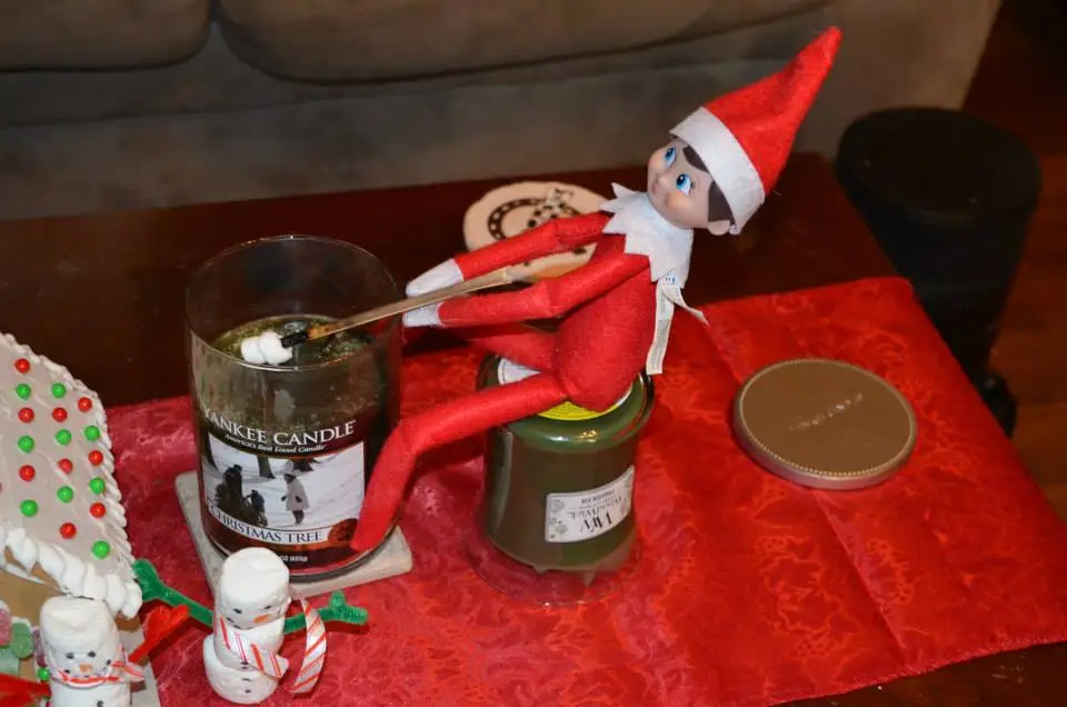 elf on the shelf roasting a marshmallow over a candle