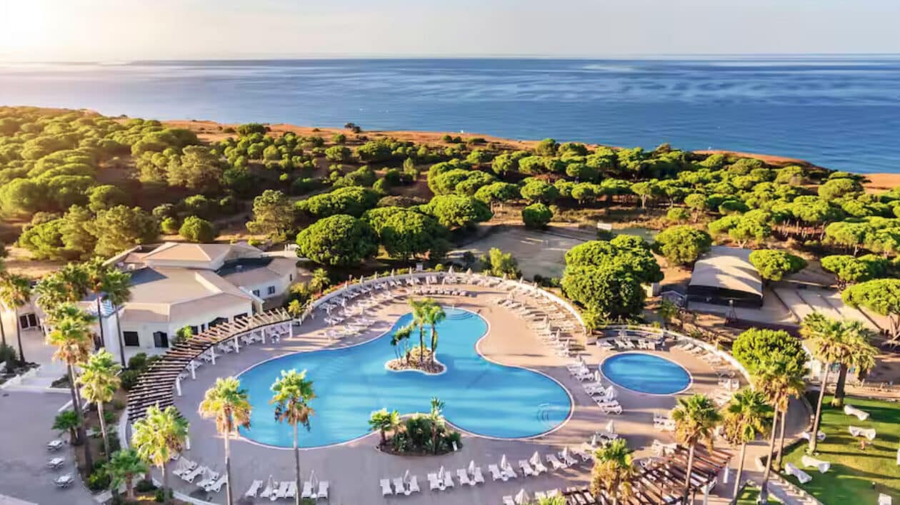 birds eye view of holiday resort with 2 pools, plenty of greenery and the ocean