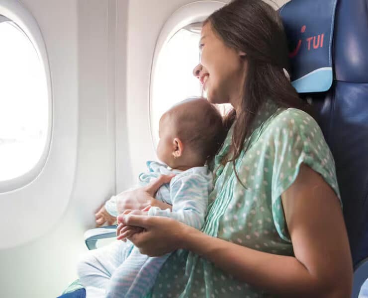 baby on mums lap on the plane